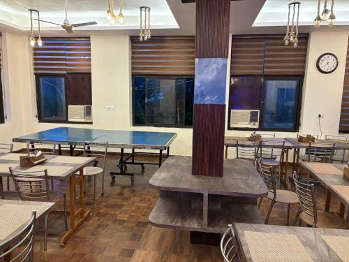 a restaurant with two ping pong tables and chairs at Corbett Treat Resort in Rāmnagar