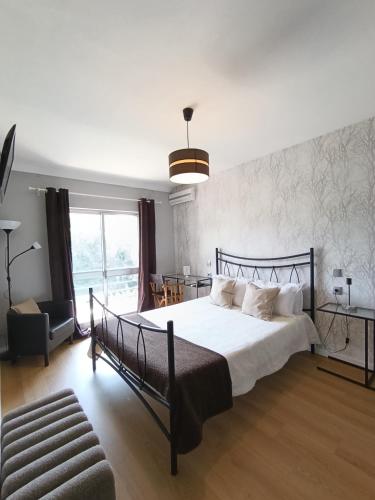 a bedroom with a large bed and a chair at Residencial Do Rita em Rio Caldo in Geres