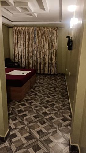 a hallway to a bathroom with a tub and a curtain at Hotel sunrise in Kodaikānāl