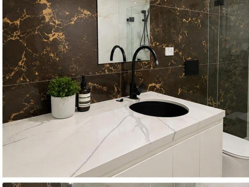 a bathroom with a white sink and a mirror at Modern Private Granny Flat Free Parking in Riverstone