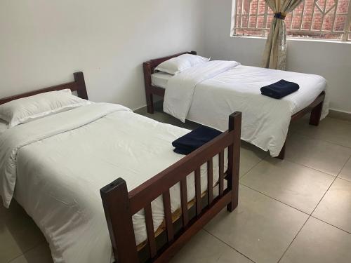 two beds sitting in a room with at Suzie's Nest 2 in Lilongwe