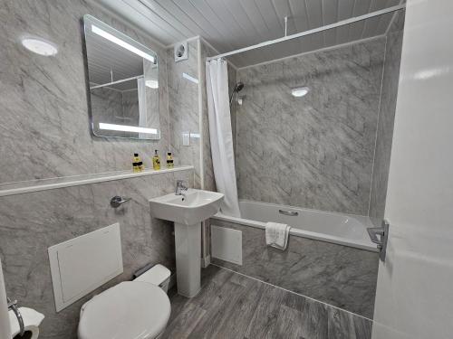 a bathroom with a toilet and a sink and a shower at Beau Rivage in St. Brelade