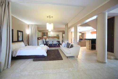 a bedroom with a white bed and a white couch at Luxury Heaven farm one in Kastoria