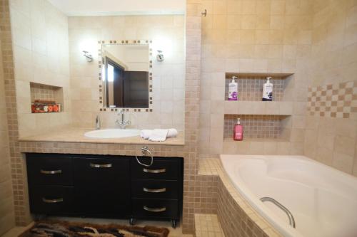 a bathroom with a tub and a sink and a tub and a mirror at Luxury Heaven farm one in Kastoria