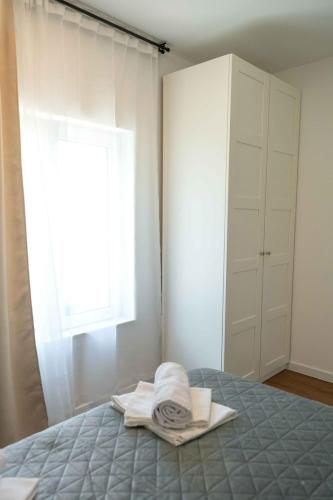 a bedroom with a bed with towels and a window at Casa Carlo in Sinj