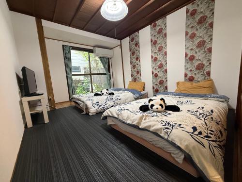 two beds with stuffed animals laying on them in a bedroom at HANA88のa,b in Otsu