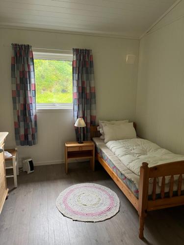 a small bedroom with a bed and a window at 2 bedroom apartment with beautiful view in Sauda