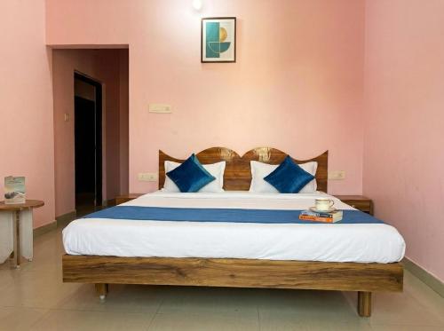 a bedroom with a large bed with blue pillows at Tapasya Palace in Gorakhpur