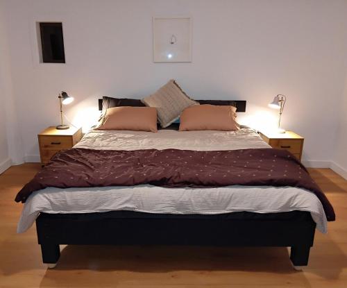 a bedroom with a large bed with two lamps at Fairview Retreat in Clunes