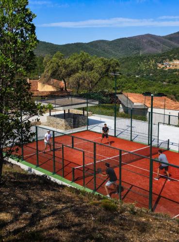a group of people playing tennis on a tennis court at La Villa Nais PADEL&PISCINE -Suites & Appartements in Bormes-les-Mimosas