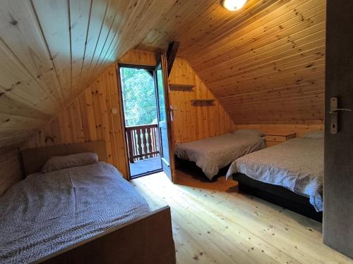 a bedroom with two beds in a log cabin at Brunarica Marička in Idrijska Bela