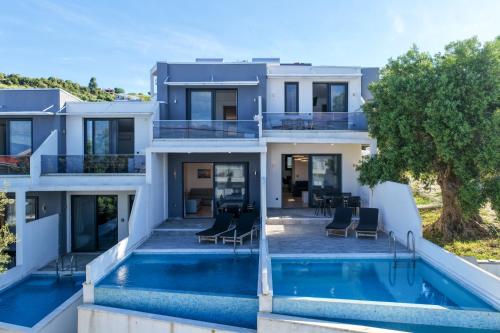 a villa with a swimming pool and a house at Villas Kaiafa “Ismini” in Polychrono