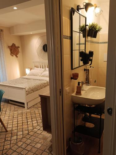 a bathroom with a sink and a bed at MancioBiba Home in Trevi