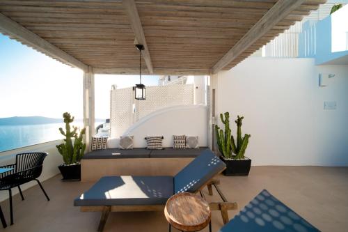a room with a bed and a table and chairs at Imera Vista Suites in Imerovigli