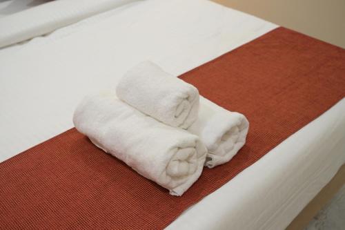 two towels sitting on top of a bed at The Bhavani Hotel in Dāhod