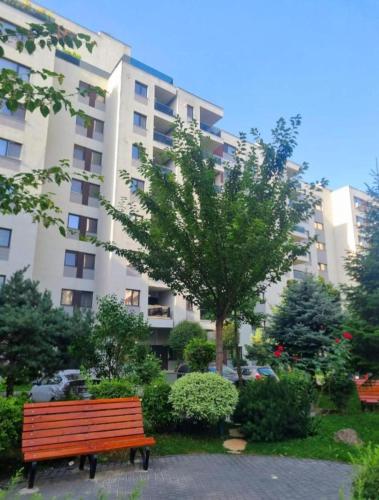 a park bench in front of a large building at Happy 2Rooms Apartament in Pipera