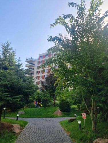 a walkway in a park with a building in the background at Happy 2Rooms Apartament in Pipera