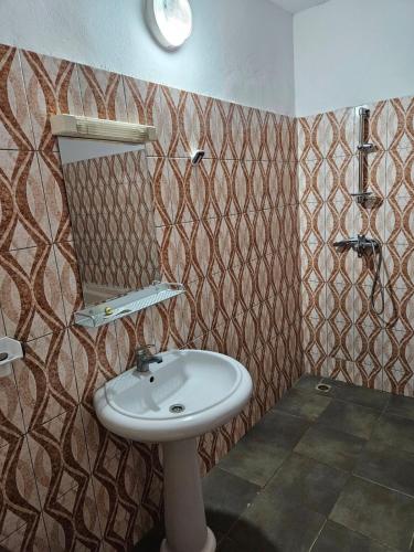 a bathroom with a sink and a mirror at Le Rêve d'Or in Lomé