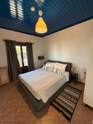 a bedroom with a large bed with a blue ceiling at Kalithea Apartement in Palekastron