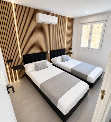a bedroom with two beds and a window at ApartamentosCRP in Almería