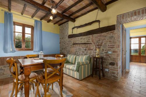 a dining room with a table and a couch at Borgo Tignano in Casole dʼElsa