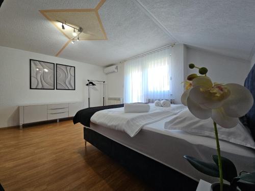 a bedroom with a large bed with a flower on it at Villa Aylin in Bihać