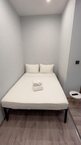 a white bed with two shoes on top of it at European District Hostel in Brussels