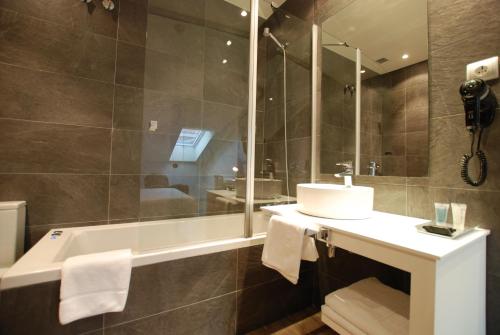 a bathroom with a sink and a tub and a mirror at Hotel Andia in Orcoyen