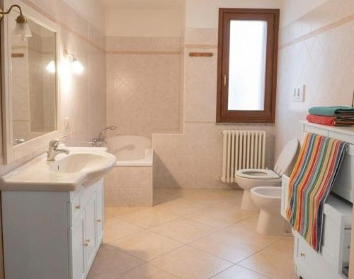 a white bathroom with a sink and a toilet at Domo Mea in Orgosolo