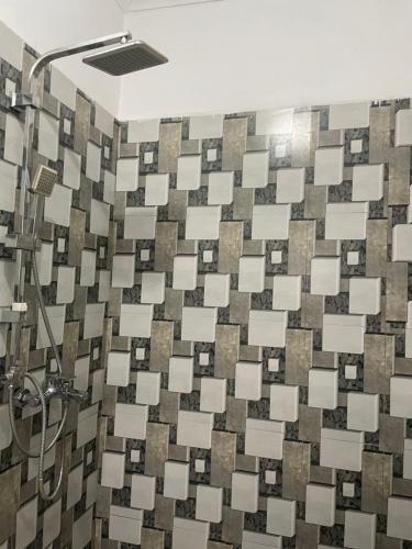 a bathroom with a shower with a tiled wall at Suzie's Nest 2 in Lilongwe