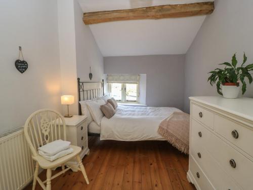 a bedroom with a bed and a chair at 2 The Gardens in Lechlade