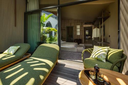 a balcony with two green chairs and a living room at Mohala Boutique Hotel in Diso