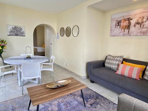 a living room with a couch and a table at Oceanic Apartment - Ocean views - Self-Catering in Durban