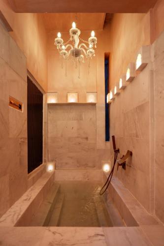 a bathroom with a chandelier and a pool of water at Misty BNB And Homestay in Jaipur