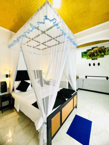 a bedroom with a bed with a canopy at Royal Mount Ella in Ella