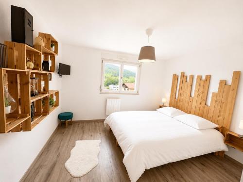 a bedroom with a large white bed and a window at Appart Vosges in Fresse-sur-Moselle