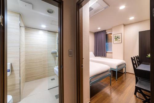 a small room with a bed and a bathroom at Soosong Guesthouse Gwanghwamun Myeongdon g in Seoul