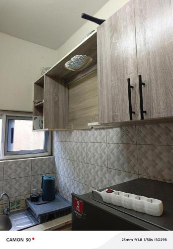 a kitchen with wooden cabinets and a counter top at or bleu in Lomé