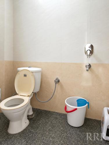 a bathroom with a toilet and a bucket at Ranibagh Riverview Retreat in Kāthgodām