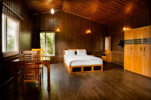 a bedroom with a bed and a desk and a television at 11 Haven Street Kodaikanal in Kodaikānāl