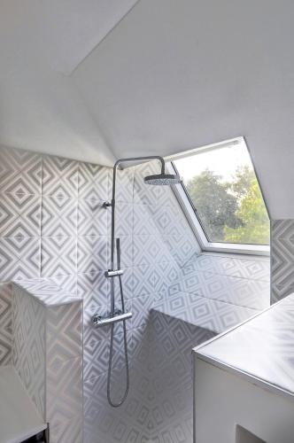 a bathroom with a shower and a window at Maison bretonne de charme in Plumergat