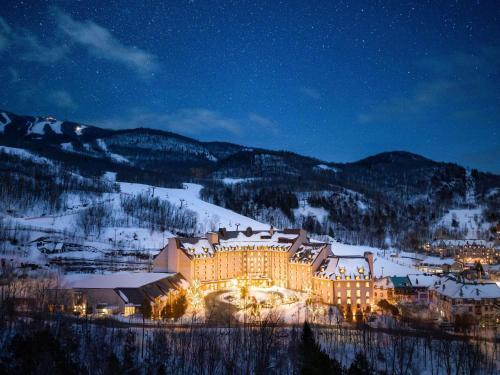a large building in the snow at night at Fairmont Tremblant in Mont-Tremblant