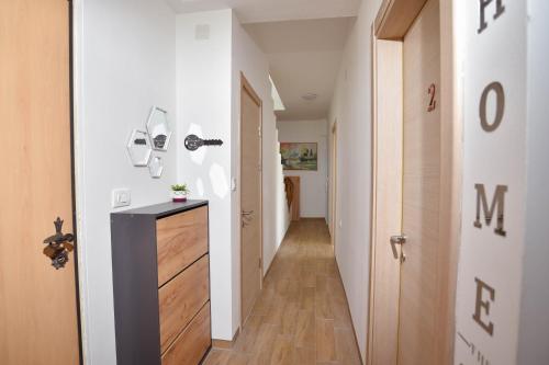 a hallway with white walls and wood floors and a door at Villa Mladost Luxury in Veles
