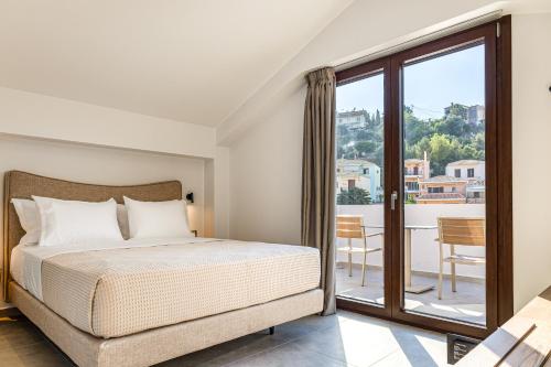 ein Schlafzimmer mit Bett und Balkon in der Unterkunft Sunstar Suites in Syvota