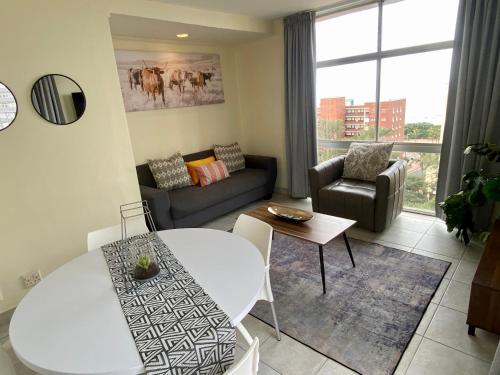 a living room with a couch and a table at Oceanic Apartment - Ocean views - Self-Catering in Durban