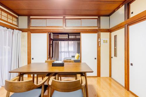 a dining room with a wooden table and chairs at AO Niigata in Niigata