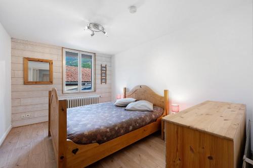 a bedroom with a wooden bed and a wooden table at Appartement Aime La Plagne in Aime-La Plagne