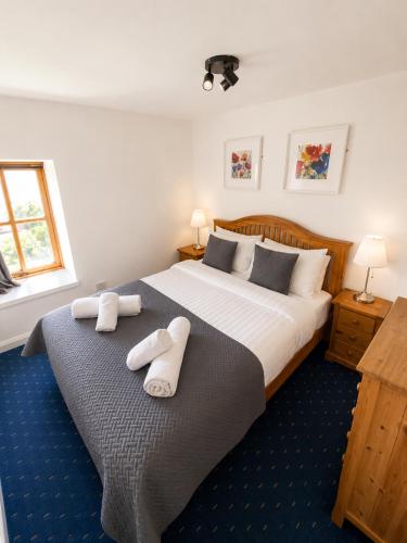 a bedroom with a large bed with towels on it at Dolphin Bay Suites in Ardersier