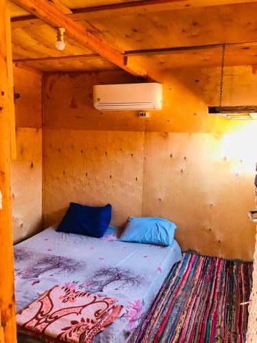 a bed in a wooden room with a ceiling at Reef Beach Camp in Nuweiba