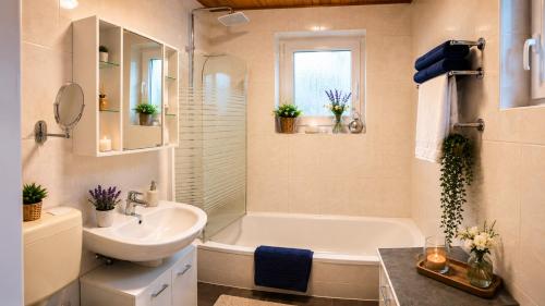 a bathroom with a sink and a tub and a toilet and a mirror at Zuhause am Bach Ruhige Unterkunft für Erholungssuchende am Welterbesteig und Donauradweg in Aggsbach